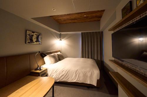 a bedroom with a bed and a flat screen tv at Hotel Resol Akihabara in Tokyo