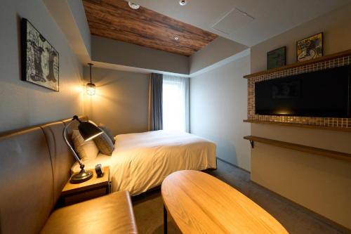 a hotel room with a bed and a tv at Hotel Resol Akihabara in Tokyo