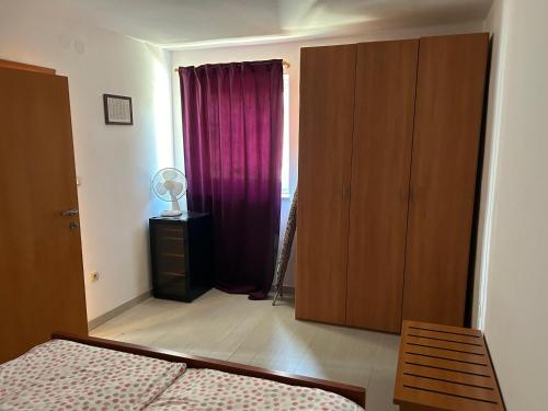 a bedroom with a bed and a closet and a window at Lucija in Karlobag