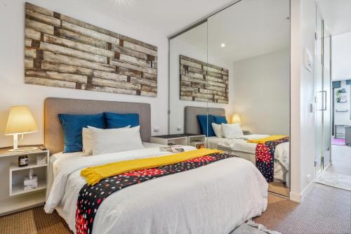 a bedroom with two beds and a mirror at Beachfront Studio Apartment in Frankston Melbourne in Frankston