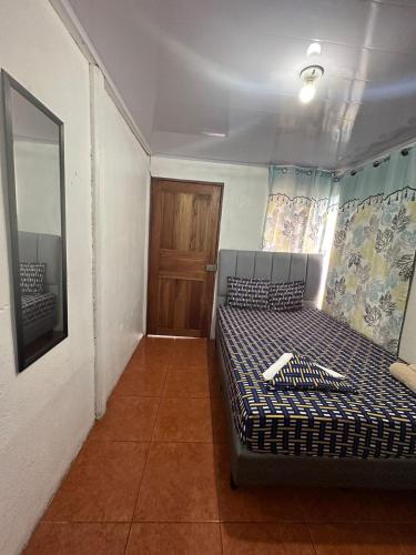 a small room with a bed and a door at La Casa de Detours Costa Rica in Fortuna
