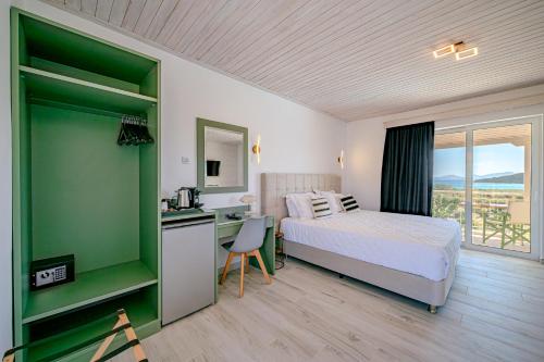 1 dormitorio con cama, escritorio y ventana en Leonidas Resort, en Ermioni