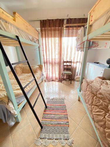 a dorm room with bunk beds and a chair at Maison D’artiste in Tirana