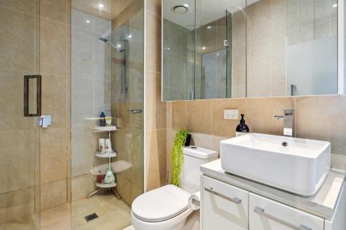 a bathroom with a sink and a toilet and a shower at Beachfront Studio Apartment in Frankston Melbourne in Frankston