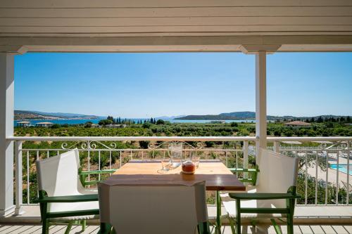 a table and chairs on a balcony with a view of the ocean at Leonidas Resort in Ermioni