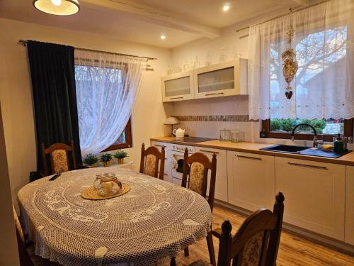 eine Küche mit einem Tisch und eine Küche mit einem Waschbecken in der Unterkunft LubięNic przytulny dom z basenem 
