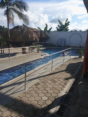 a resort swimming pool with a statue in the background at Eden Hotel in El Peñol
