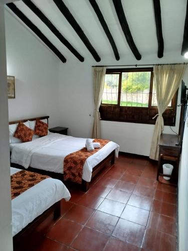 a bedroom with two beds and a window at Hotel MAXIRUMA - Villa TAMAUKA in Iza