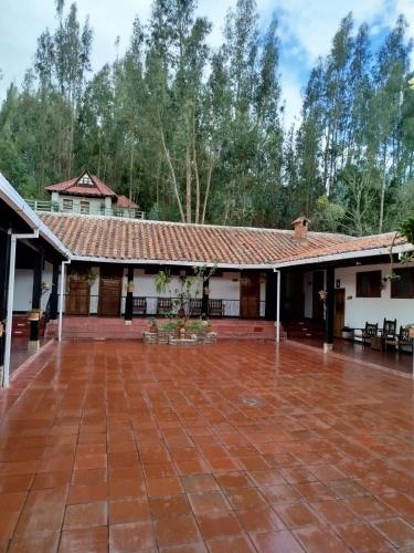 an empty courtyard of a building with a red tile roof at Hotel MAXIRUMA - Villa TAMAUKA in Iza