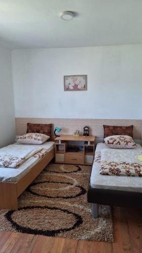 a room with two beds and a rug at Dijanin Konak in Zvornik