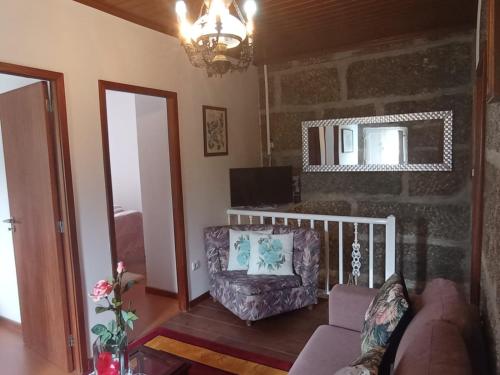 a living room with a couch and a chair at Casa das Leiras in Loivos da Ribeira