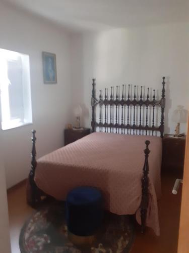 a bedroom with a bed with a wooden headboard at Casa das Leiras in Loivos da Ribeira