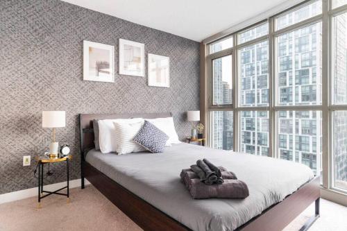 a bedroom with a large bed with a large window at SkyHigh Haven LED-Lit Downtown Condo Retreat in Toronto