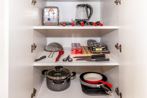 a kitchen shelving unit with a pot and other kitchen items at SkyHigh Haven LED-Lit Downtown Condo Retreat in Toronto