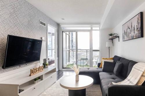a living room with a couch and a tv at SkyHigh Haven LED-Lit Downtown Condo Retreat in Toronto