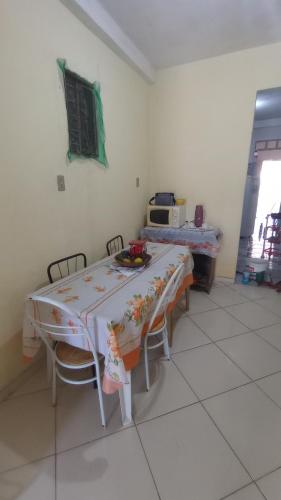 uma mesa e cadeiras num quarto com uma mesa e um micro-ondas em Casa hostel quarto dormitório estudantil em Ilhéus