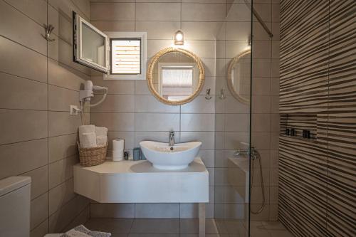 a bathroom with a sink and a glass shower at Leonidas Resort in Ermioni