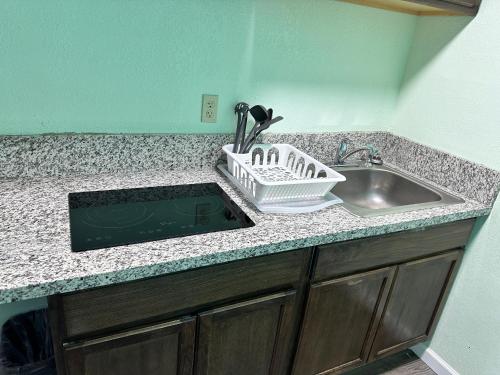 a kitchen counter with a sink and a dish drying rack at Super 8 by Wyndham Yreka in Yreka
