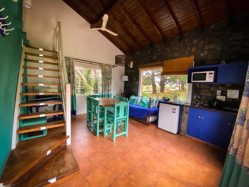 a kitchen and dining room with blue cabinets and a table at Cabañas Refugio del Ángel in Tandil