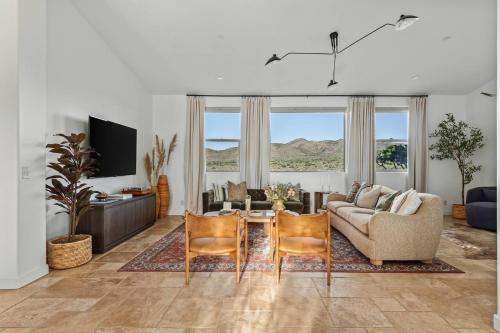 een woonkamer met een bank en een tafel en stoelen bij Sunstone Pool, Hot Tub & Mountain Views! in Yucca Valley