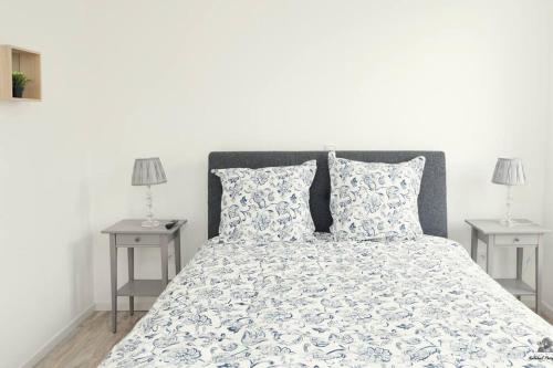 une chambre avec un grand lit avec deux tables de nuit dans l'établissement La résidence Jeanne d'Arc 4, Troyes-France, à Troyes