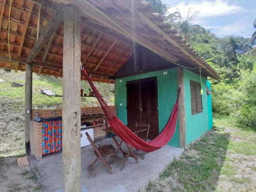 a house with a hammock outside of it at Chalé Floresta Toca da Serra in Iporanga