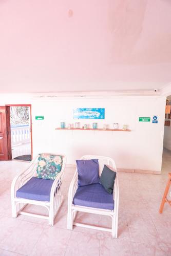 two chairs sitting next to each other in a room at Hostal Palo Alto in San Andrés