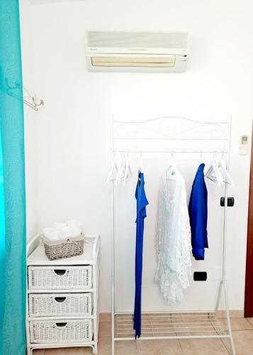 Una habitación con un armario con un vestido y un ventilador. en Casa Flo, en Villasimius