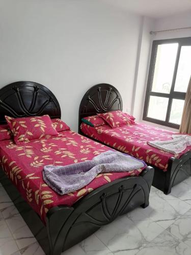 two beds sitting next to each other in a room at شاليه غرفة ورسيبشن وحمام ومطبخ عماره 6 الدور الثاني 6232 in Port Said