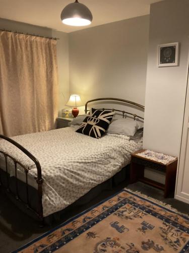 a bedroom with a bed with pillows and a rug at Private Room in a house in the Cotswolds in Bredon