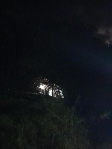 a night view of a hill with the moon in the background at Chalé Floresta Toca da Serra in Iporanga