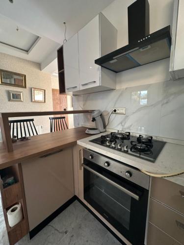 a kitchen with a stove and white cabinets at Coquette villa avec piscine in Tunis