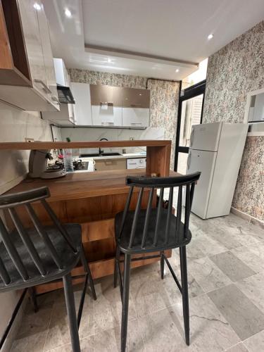 a kitchen with two black chairs and a counter at Coquette villa avec piscine in Tunis