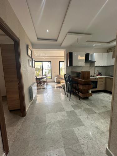 a kitchen and living room with a table and chairs at Coquette villa avec piscine in Tunis