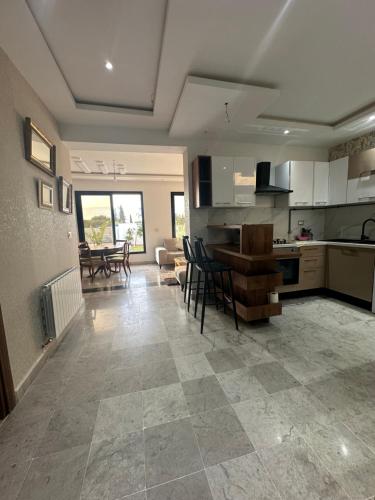 a kitchen and living room with a table and chairs at Coquette villa avec piscine in Tunis