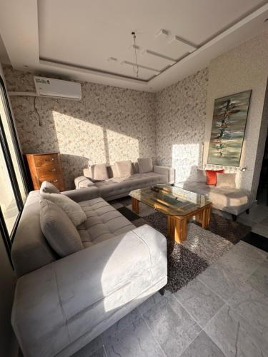 a living room with a couch and a table at Coquette villa avec piscine in Tunis
