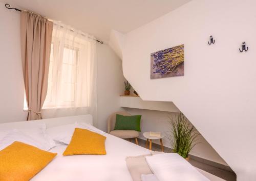 a bedroom with a white bed with yellow pillows at Lavanda in Tribunj
