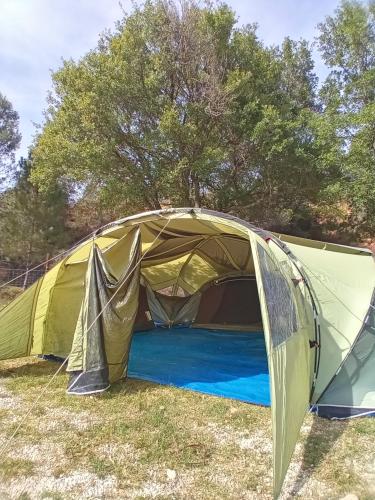 une tente dans un champ avec des arbres en arrière-plan dans l'établissement El Rebost de Penyagalera, à Beceite