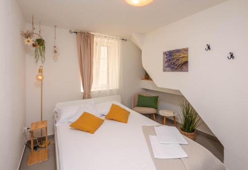 a bedroom with a white bed with orange pillows at Lavanda in Tribunj