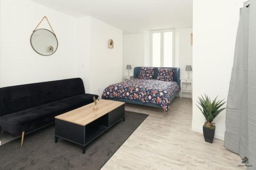 - un salon avec un canapé noir et un lit dans l'établissement La résidence Jeanne d'Arc 1 , Troyes - France, à Troyes
