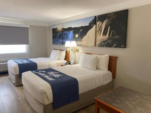 アーリントンハイツにあるDays Inn & Suites by Wyndham Arlington Heightsのベッド2台とテーブルがあるホテルの部屋