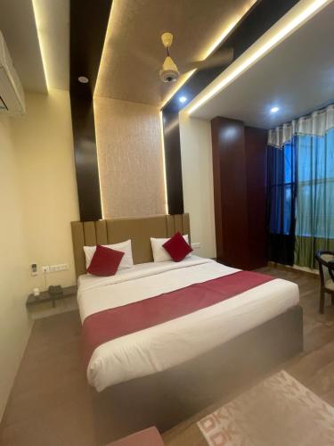 een slaapkamer met een groot bed met rode kussens bij Hotel City Star Family Stay in Mathura