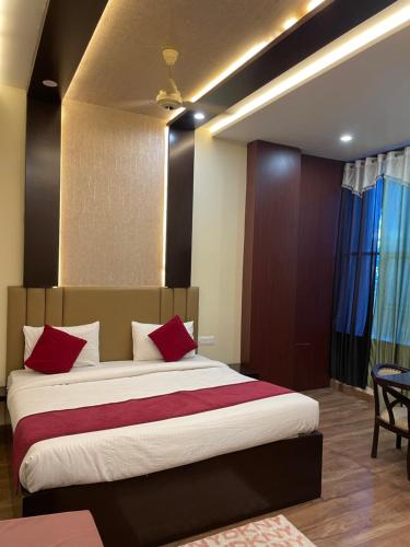 1 dormitorio con 1 cama grande con almohadas rojas en Hotel City Star Family Stay en Mathura