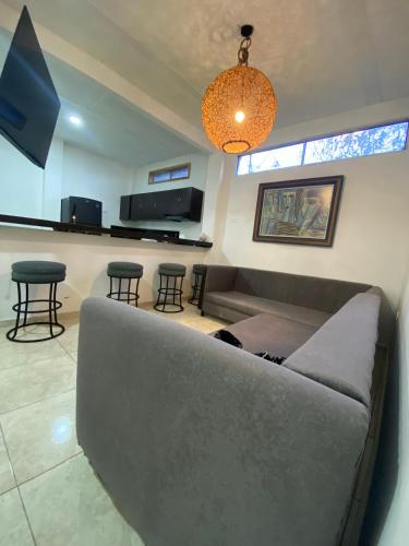 a living room with a couch and a bar with stools at Mahalo Hostel in Salento