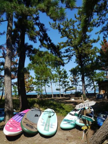 a group of surfboards lined up next to trees at Kanzaki Beach House in Kanzaki