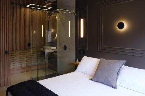 - une chambre avec un lit blanc et une douche dans l'établissement BINDI, à Salento
