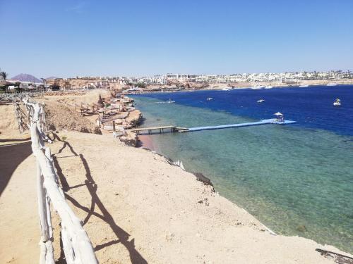 a beach with a white fence and the water at Chalet NEMO, vista mare, Sharks Bay, Sharm el Sheikh in Sharm El Sheikh