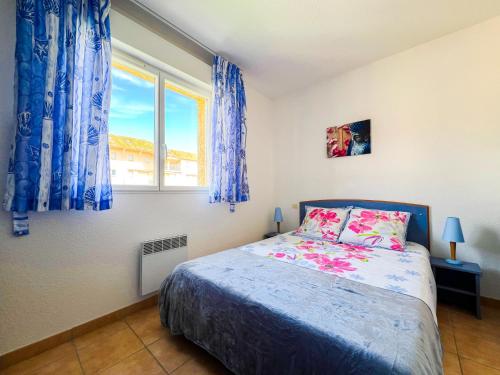 une chambre avec un lit et une fenêtre avec des rideaux bleus dans l'établissement Maison Familiale dans le Domaine de la Plage avec Piscine Privée, à 200m de la Mer, à Valras-Plage