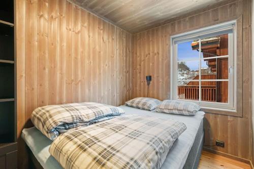 a bedroom with two pillows on a bed with a window at Cozy Apartment close to Hovden alpine centre in Hovden