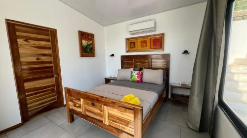 a bedroom with a bed with a wooden headboard at Canavida Villas & Resort in Uvita